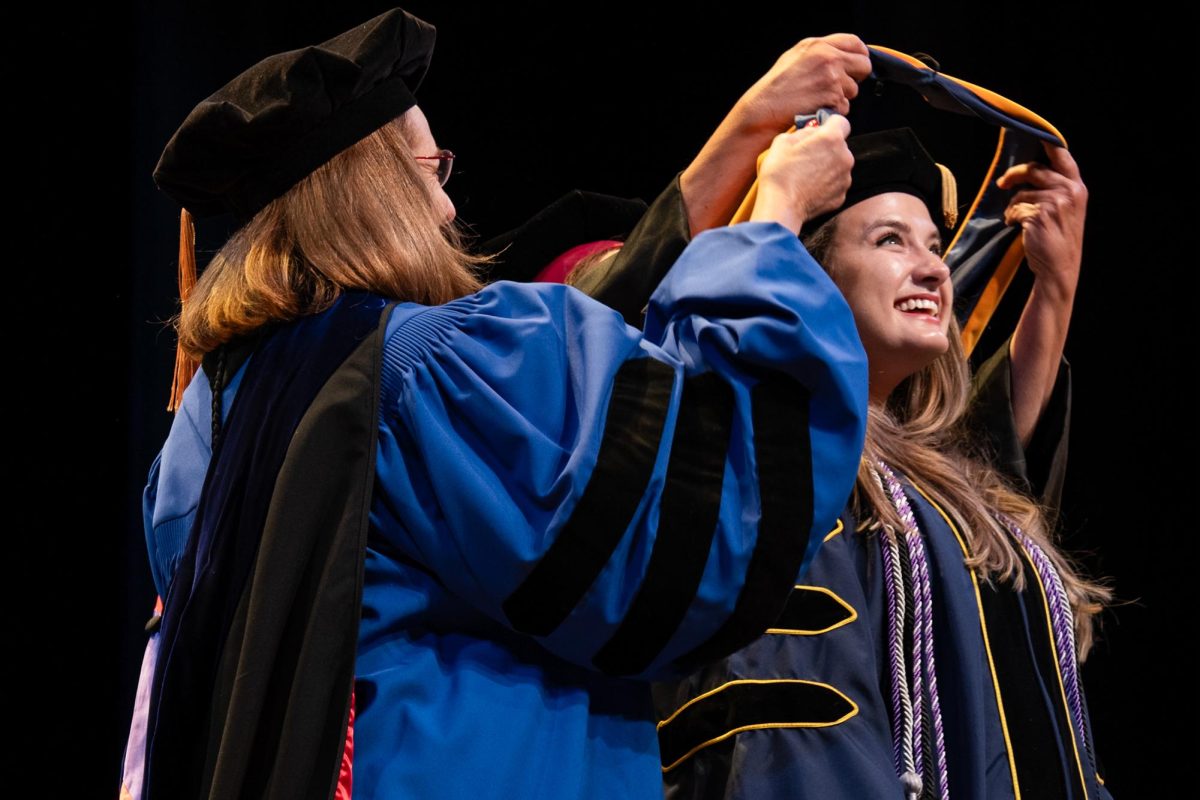 A graduate receives a hood during the School of Nursing ceremony Friday. 